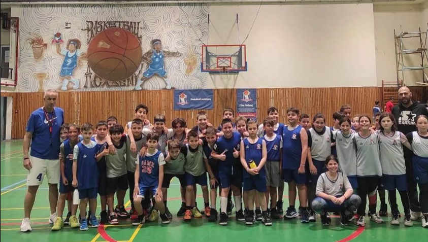 Group of young athletes, posing for a team photo. With their coaches.